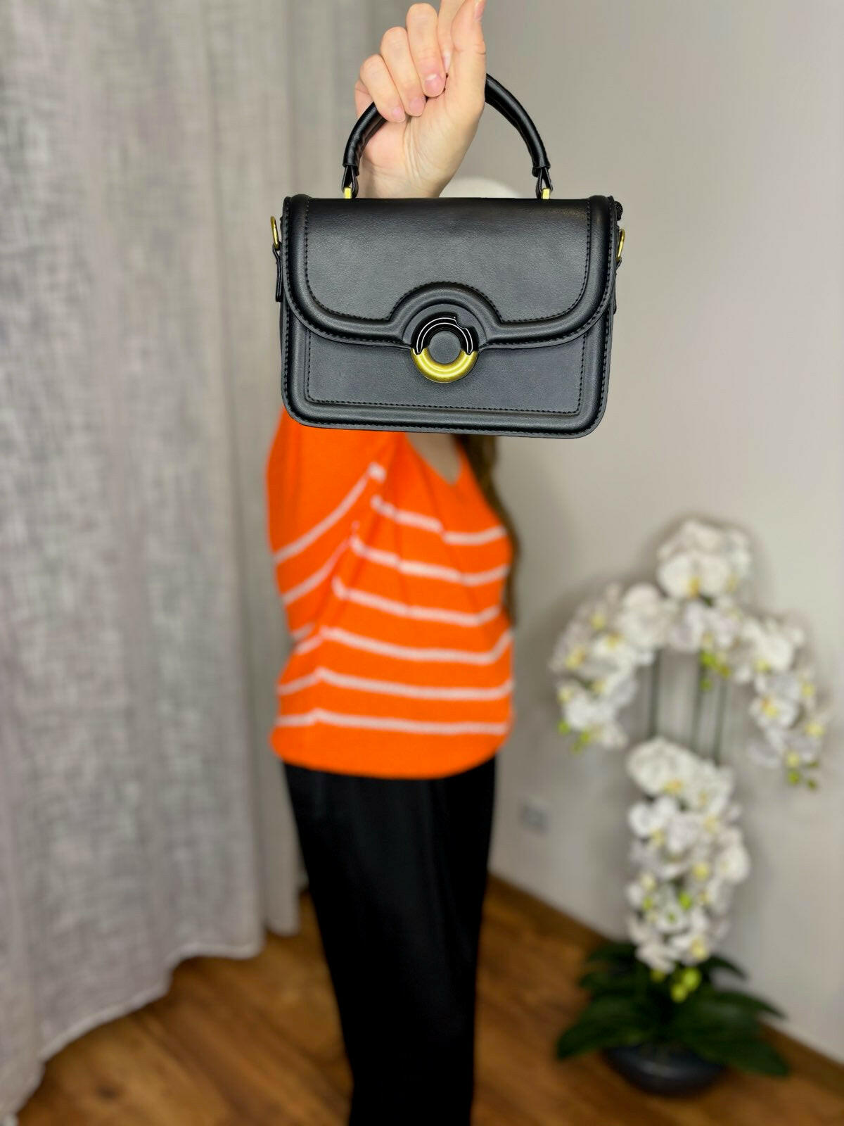 Sac 100% synthétique Doublure 100% polyamide Poignée avec une chaîne amovible jointe Fermeture avec bouton à pression Ce modèle est proposé en deux coloris : noir, rose poudrée