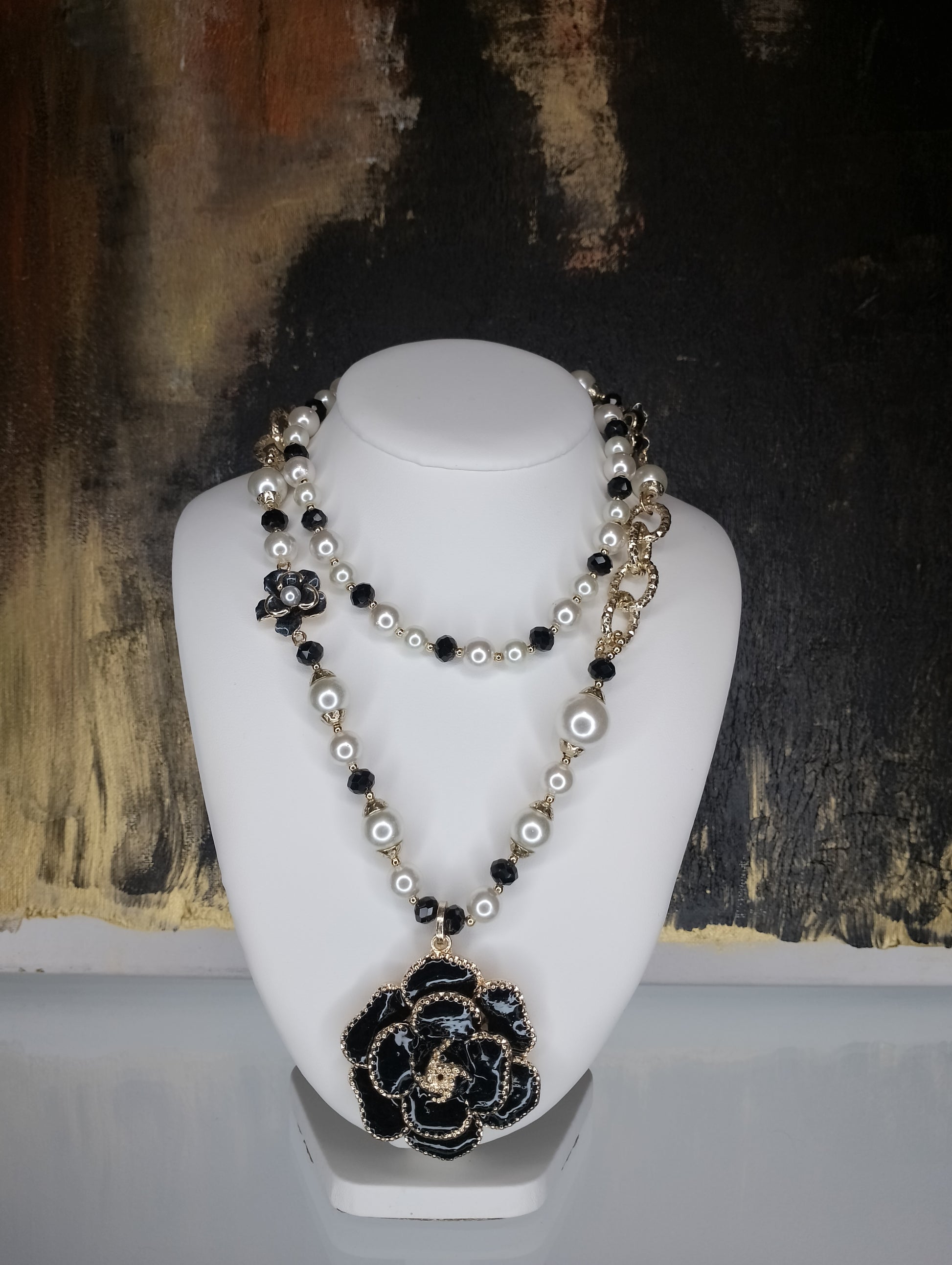 <ul> <li>Collier en perle blanche et noire, sans nickel et de couleur dorée<br></li> <li>Composé d'une fleur en son centre et d'autres fantaisies sur le long des perles<br></li> <li>Le collier est non réglable car ne possède pas de fermoir (photo non contractuelle - le collier ne peut être utilisé comme sur les photos 1 et 3, mais uniquement comme sur la photo 2)</li> <li>Longueur : 45cm et fleur de 5cm</li> </ul>