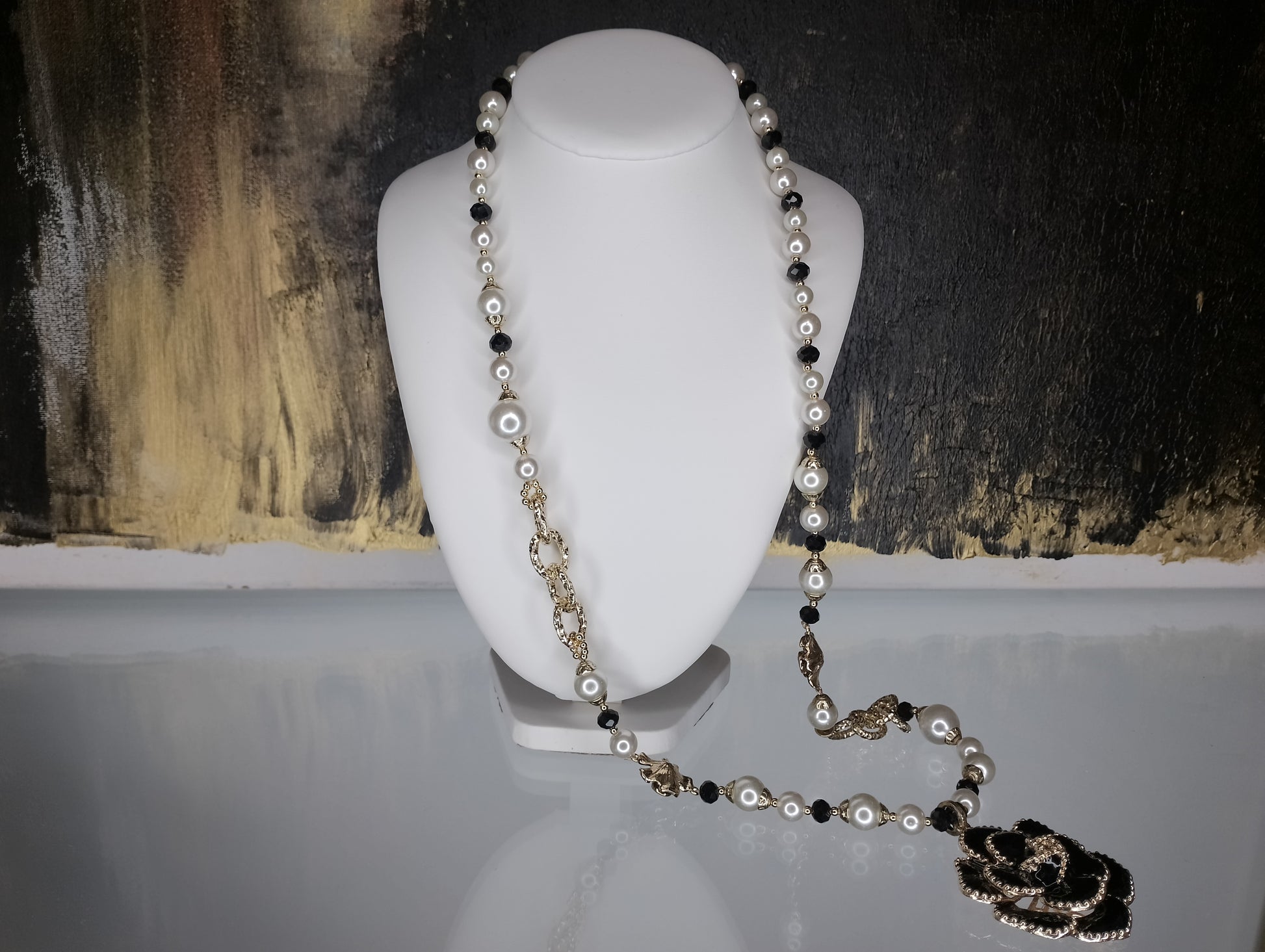 <ul> <li>Collier en perle blanche et noire, sans nickel et de couleur dorée<br></li> <li>Composé d'une fleur en son centre et d'autres fantaisies sur le long des perles<br></li> <li>Le collier est non réglable car ne possède pas de fermoir (photo non contractuelle - le collier ne peut être utilisé comme sur les photos 1 et 3, mais uniquement comme sur la photo 2)</li> <li>Longueur : 45cm et fleur de 5cm</li> </ul>