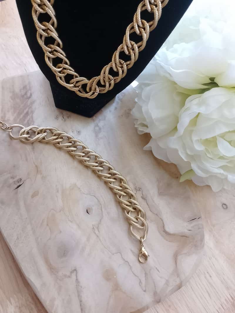 Bracelet et collier Iris gourmette dorée tressée sur marbre blanc fleurs blanches, bijoux set femme BONITALUZ