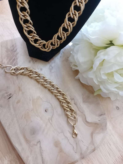Bracelet et collier Iris gourmette dorée tressée sur marbre blanc fleurs blanches, bijoux set femme BONITALUZ