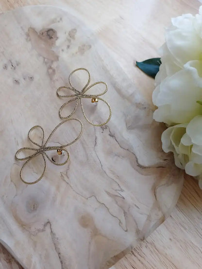Boucles d'oreilles Marguerite fleur dorée filaire pétales ajourés fond marbre fleur blanche bijou femme BONITALUZ