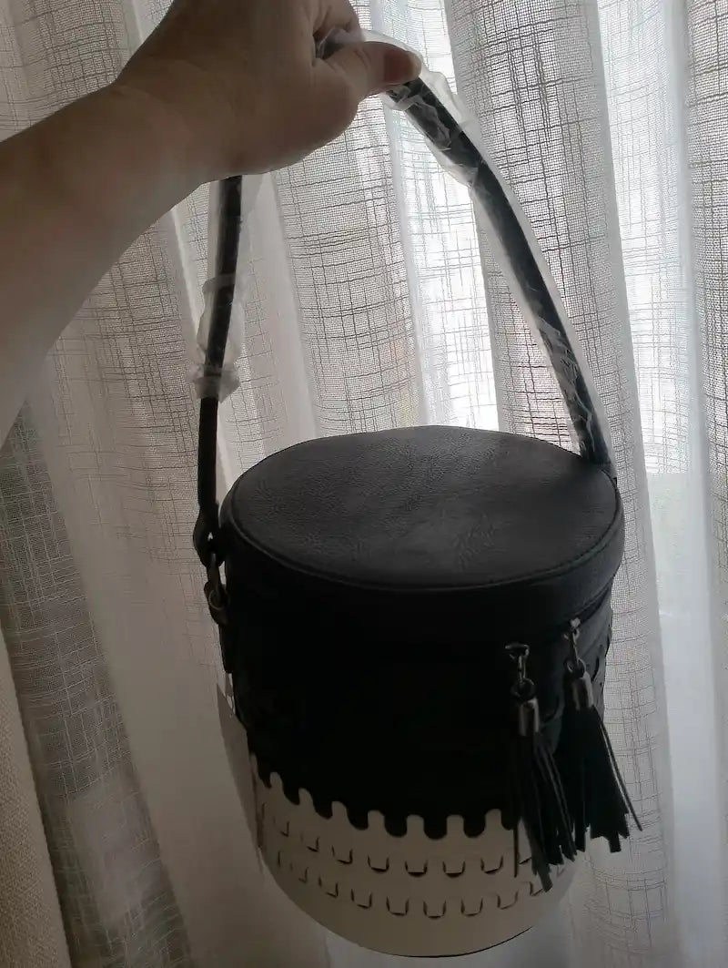Sac seau Arlequin noir porté à la main anses corde tressée devant rideau blanc style urbain BONITALUZ