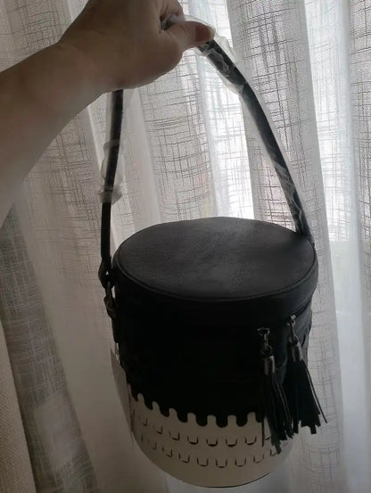 Sac seau Arlequin noir porté à la main anses corde tressée devant rideau blanc style urbain BONITALUZ