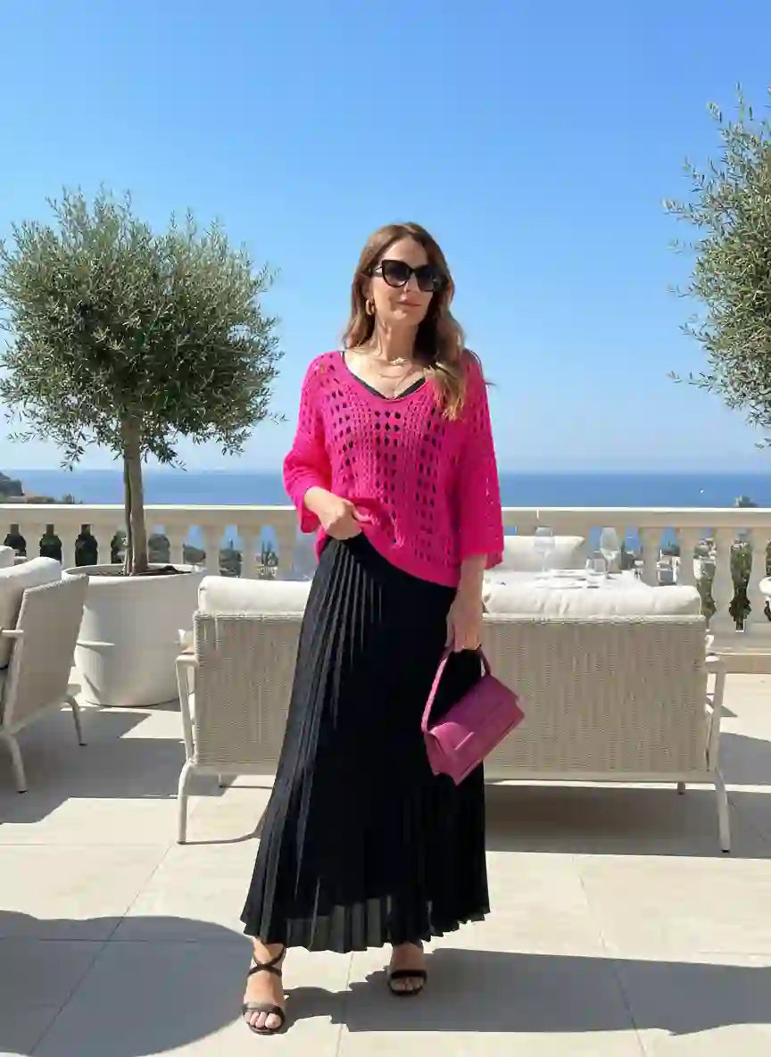 Pull femme rose fuchsia crochet ajouré jupe longue plissée noire sandales plates noires sac rose terrasse luxe vue mer méditerranée olivier piscine look vacances chic côte d'Azur BONITALUZ